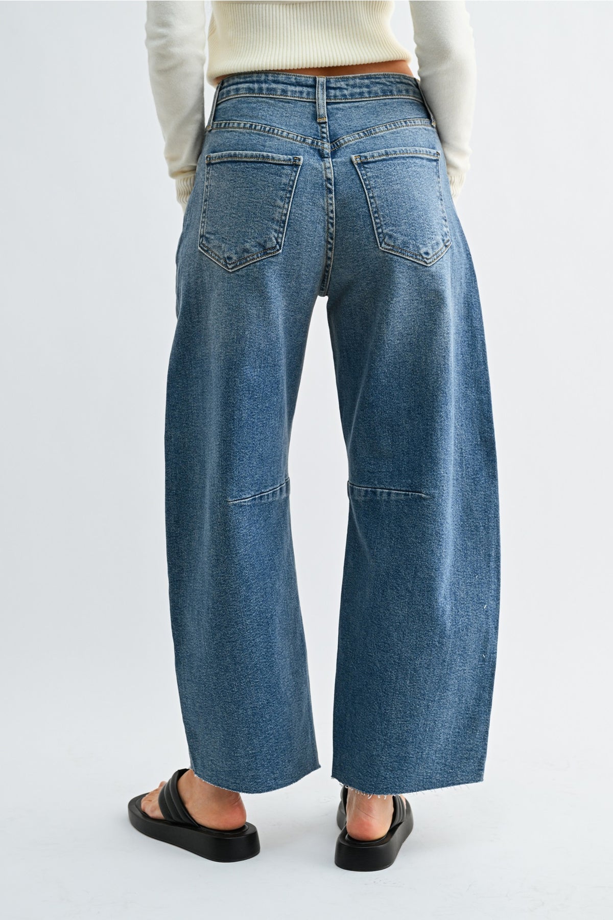 A person modeling the back of blue jeans