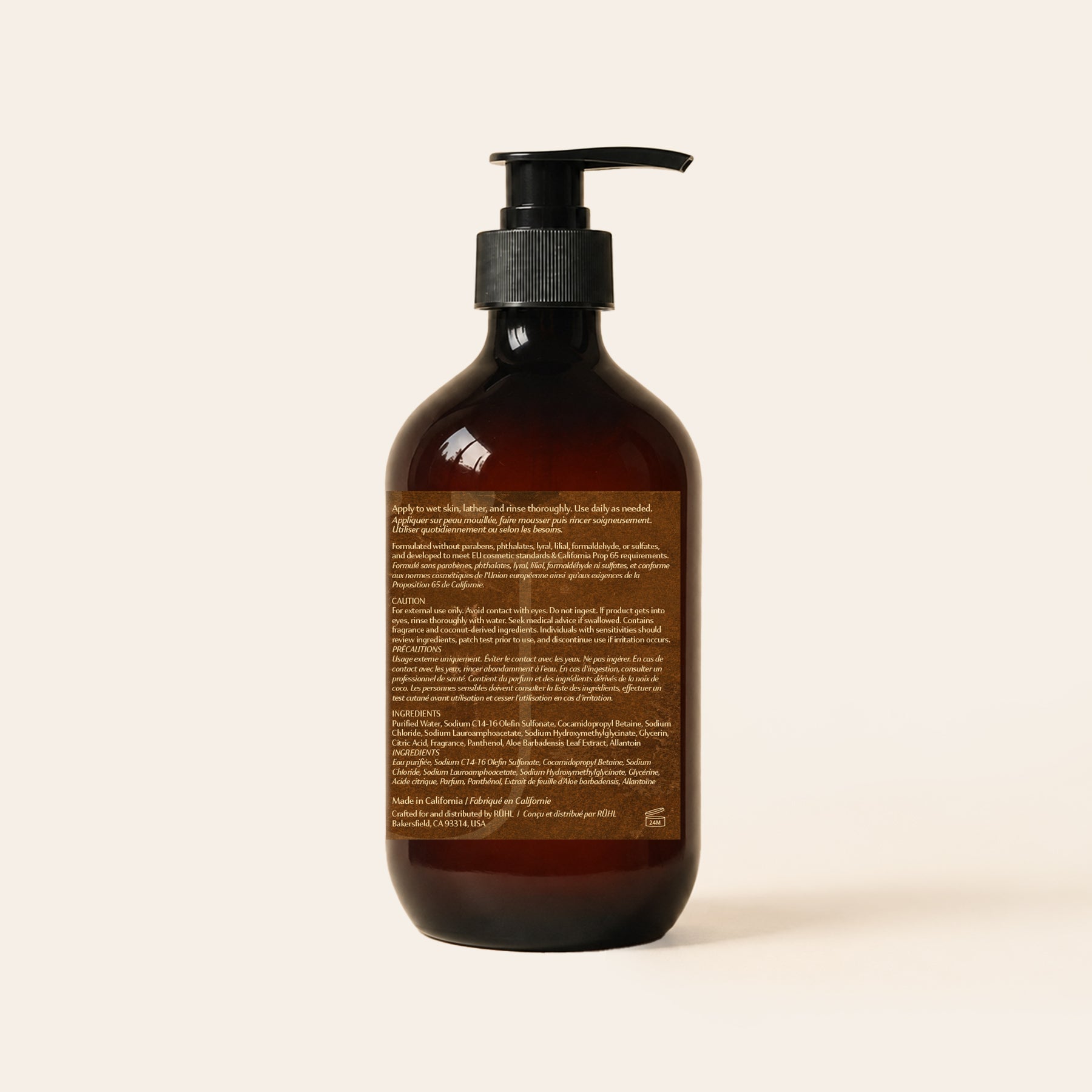 An amber glass pump bottle with a black dispenser and a brown label, shown from the back against a light beige background.